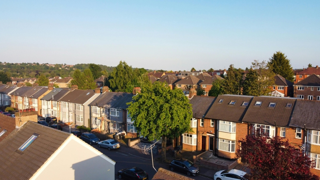 Aerial view of UK suburban residential street with terraced houses and parked cars